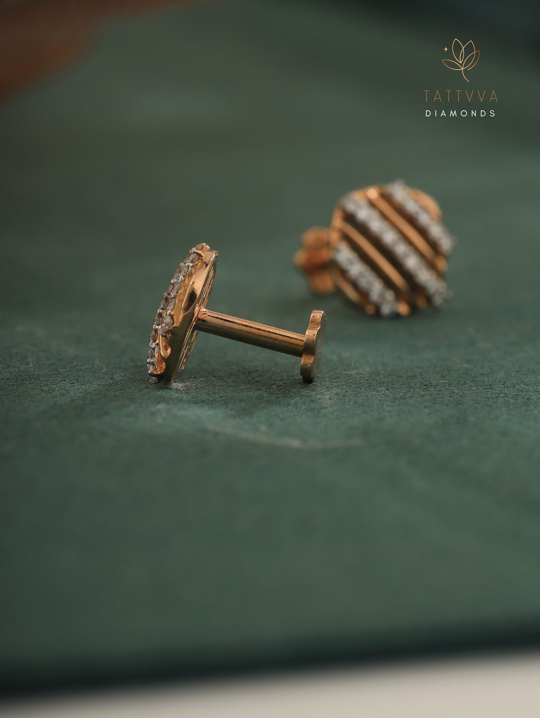 Pair of diamond-studded earrings on a green background with Tattvva Diamonds logo.