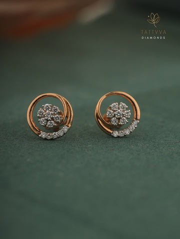 Rose gold earrings with diamond accents on a green background, branded 'Tattvva Diamonds'.