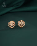 Rose gold earrings with diamond accents on a dark green fabric background, featuring the Tattvva Diamonds logo.