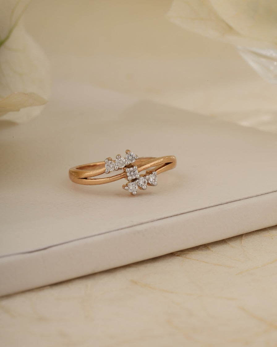 Rose gold ring with diamonds on a beige surface