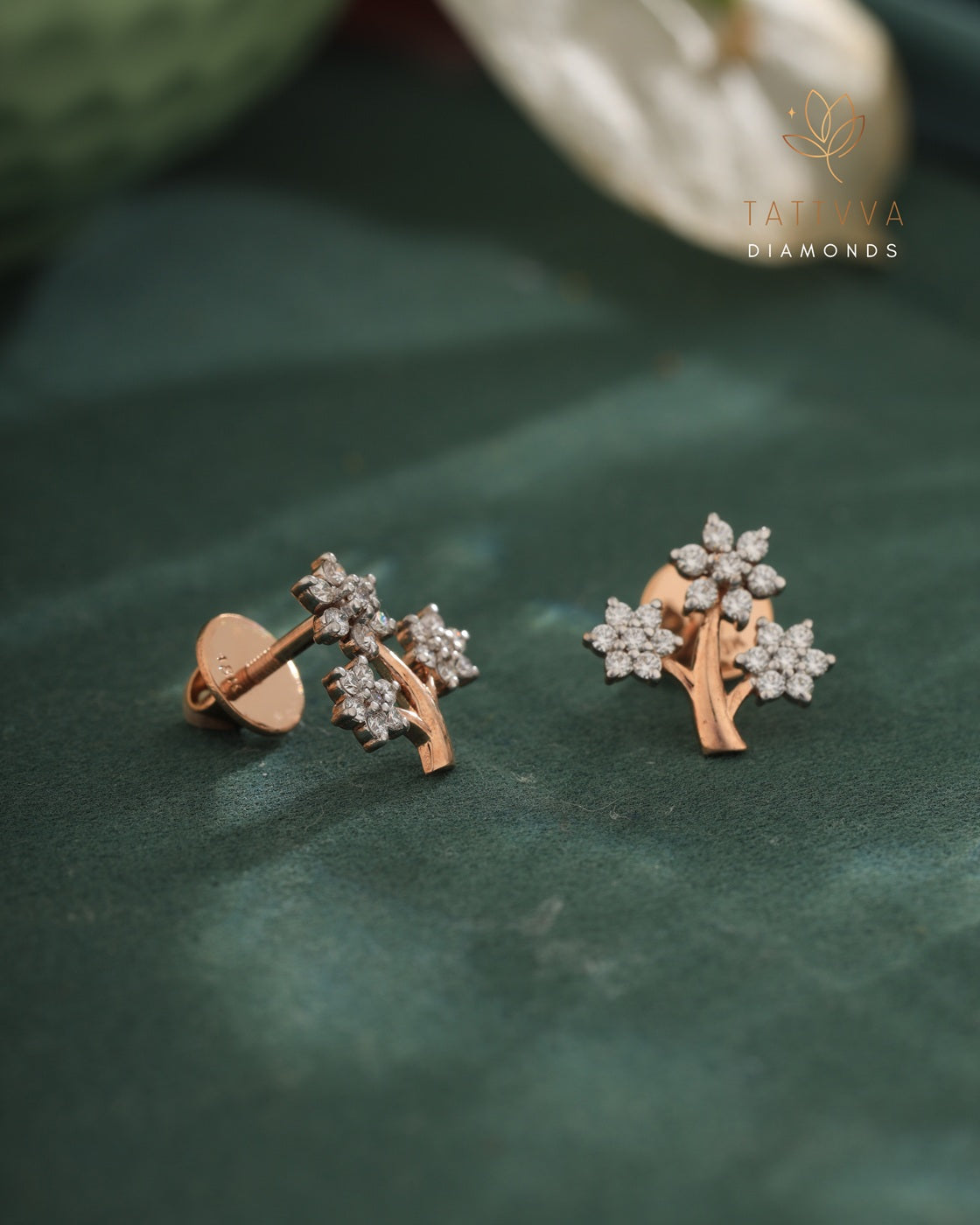 Rose gold earrings with diamond accents on a green leaf, branded 'Taraiva Diamonds'.