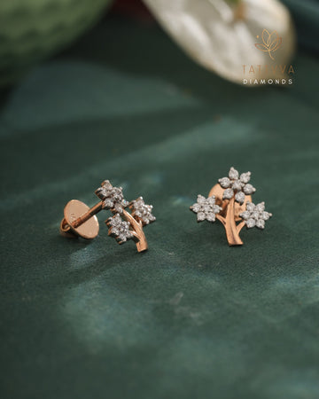 Rose gold earrings with diamond accents on a green leaf, branded 'Taraiva Diamonds'.