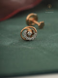 Rose gold earring with diamonds on a green surface, branded 'Tatvva Diamonds'.