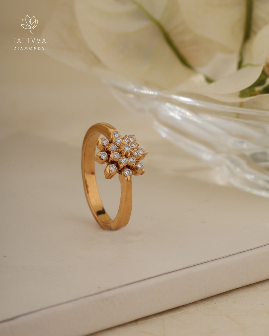 Gold ring with diamond accents on a beige surface, branded 'Tattvva Diamonds'.
