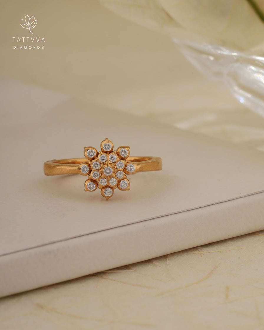 Gold ring with diamond accents on a beige surface, branded 'Tattvva Diamonds'.