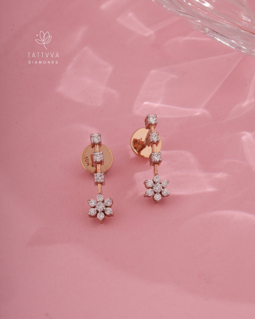 Rose gold earrings with diamond accents on a pink background, featuring Tattvva Diamonds logo.