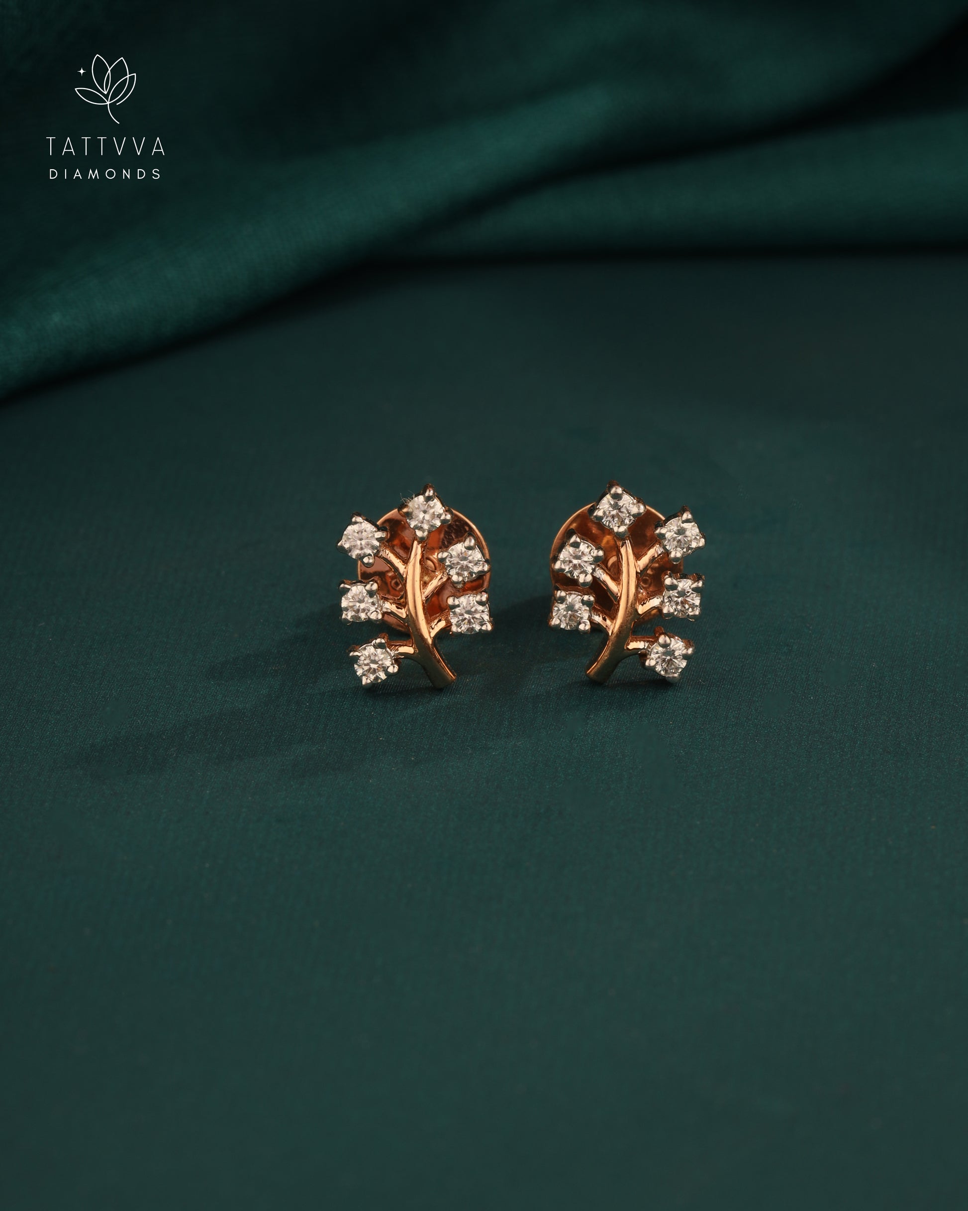 Rose gold earrings with diamond accents on a green fabric background, branded 'Tattvva Diamonds'.