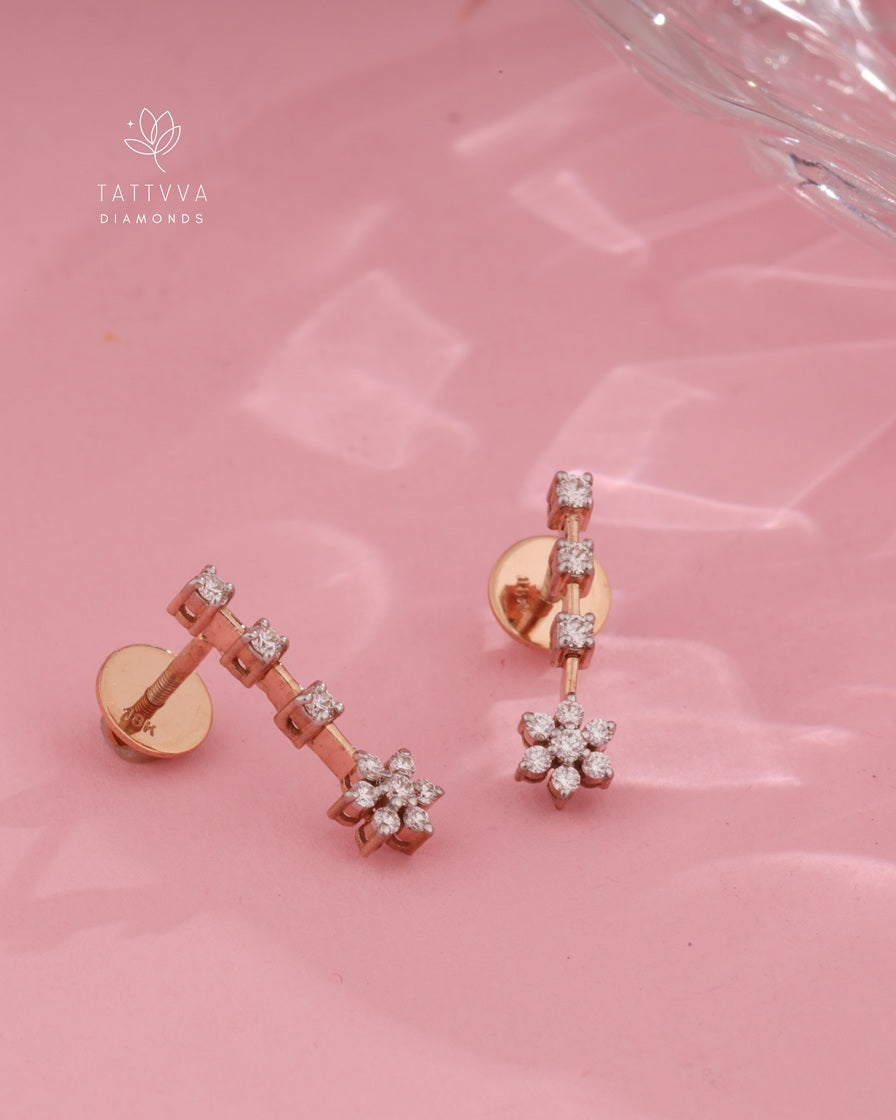 Rose gold earrings with diamond accents on a pink background, featuring the Tattvva Diamonds logo.