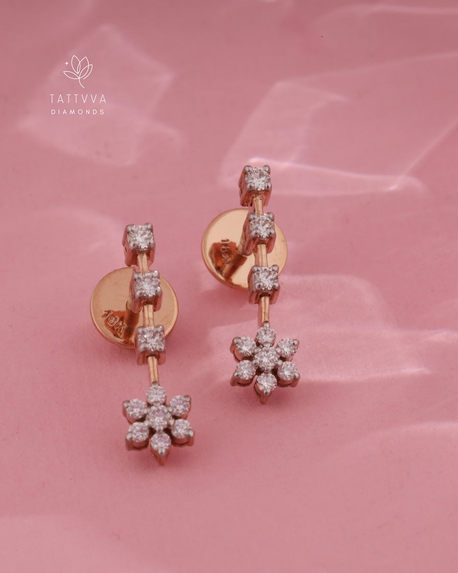 Rose gold earrings with diamond accents on a pink background, featuring the Tattvva Diamonds logo.