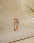 Rose gold ring with diamonds on a light background